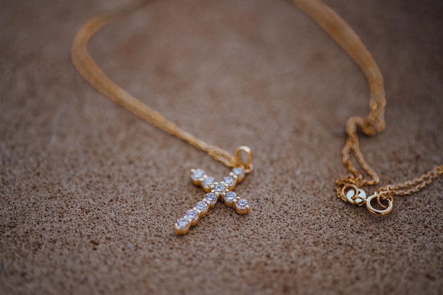 Gold cross necklace for a christening, detail photo by a Protaras christening photographer