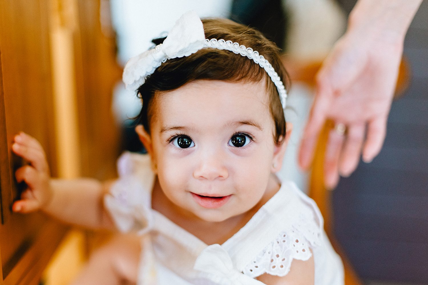 Portrait of baby Chloe with a white bow headband on her christening day, Protaras