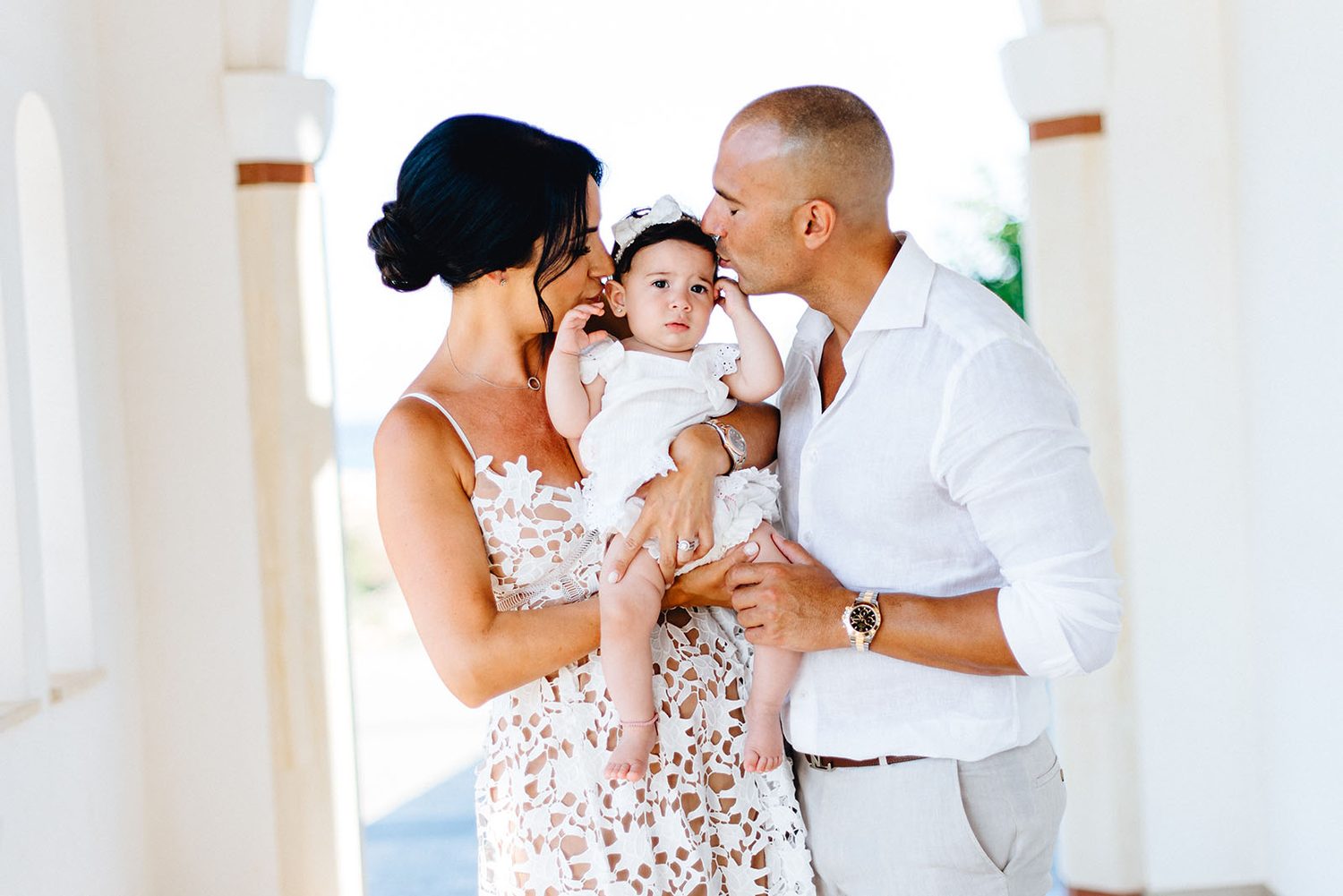 godmother kissing baby Chloe with godfather beside her, christening photographer Protaras