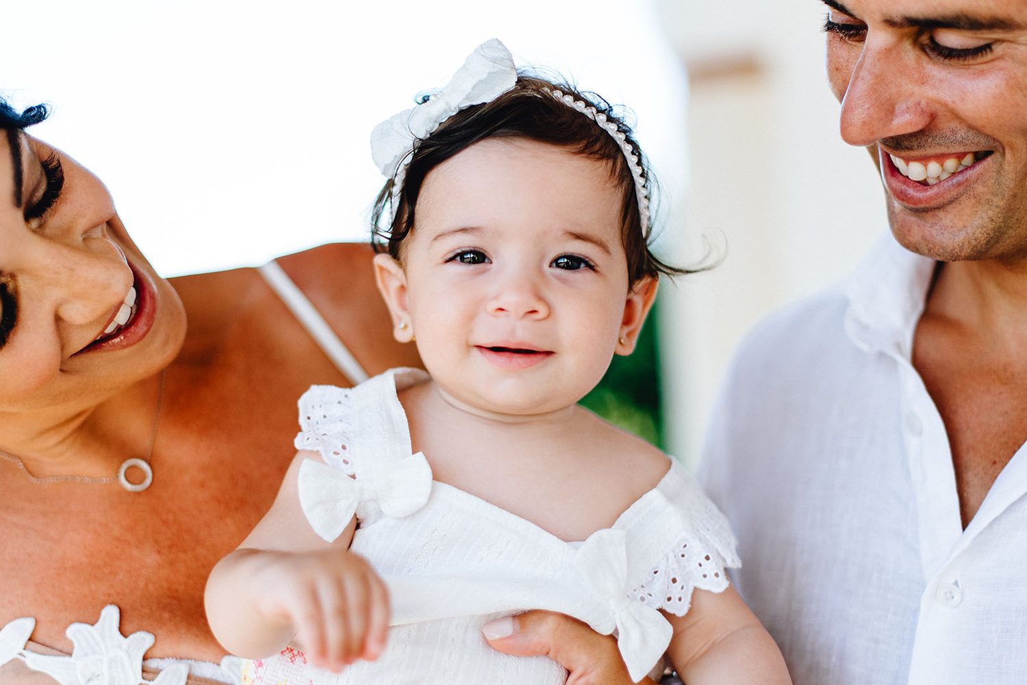 Close-up of baby Chloe smiling with her godparents, christening day in Protaras