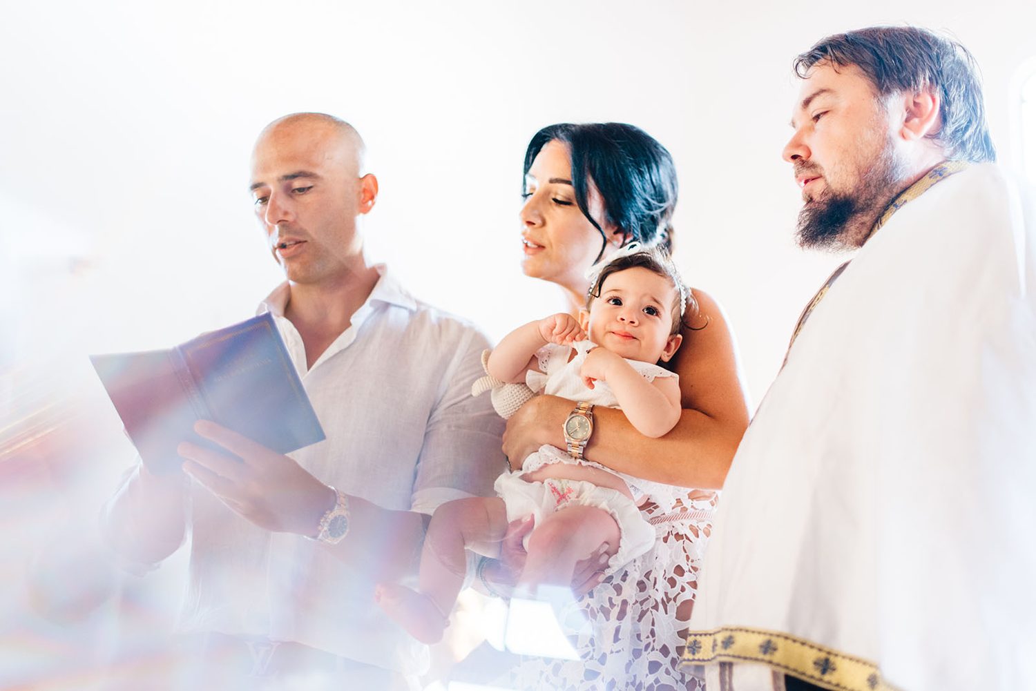 Priest and godparents reading prayers during Chloe’s christening in Protaras