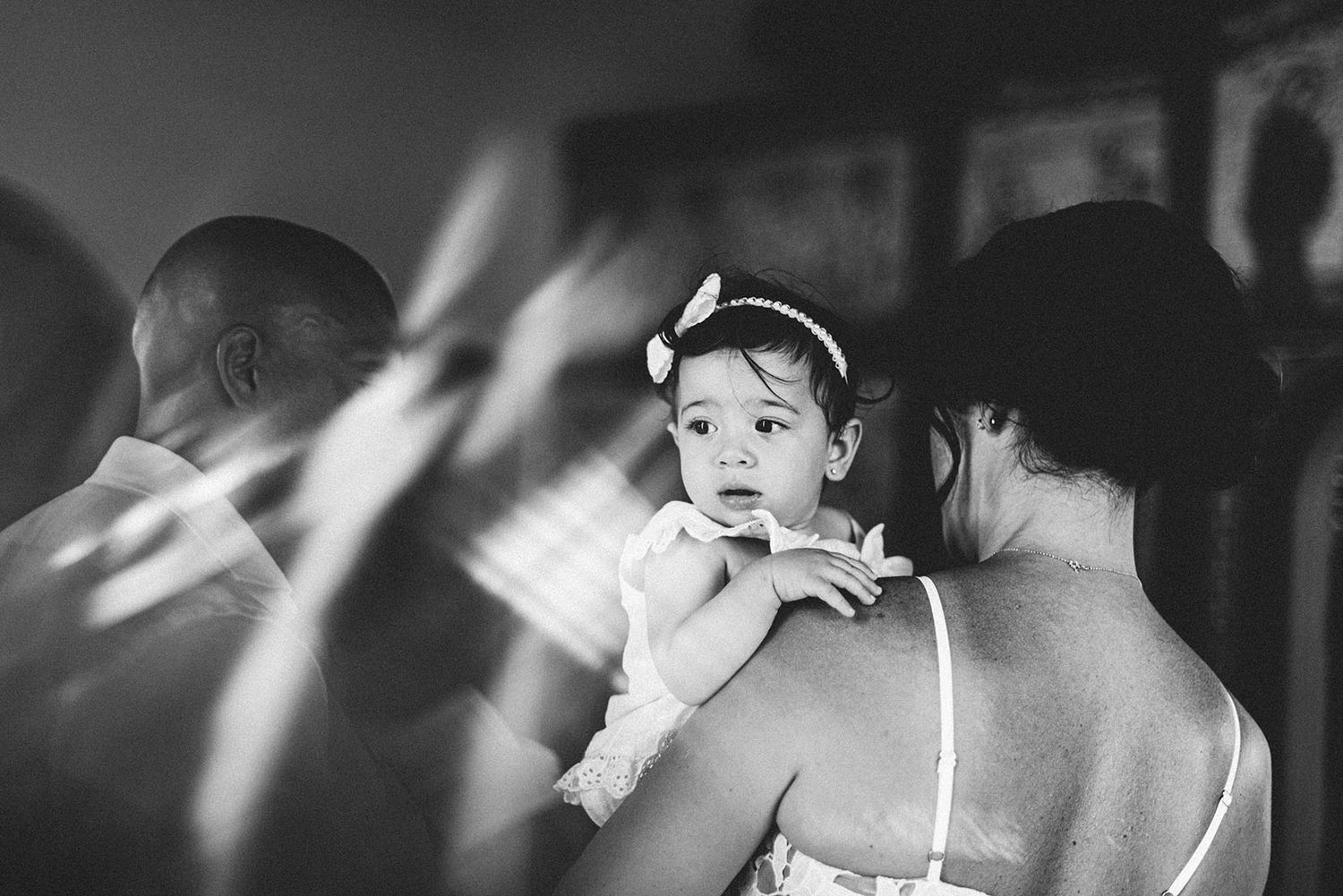 Black and white photo of baby Chloe in godmother’s arms during the ceremony, Protaras