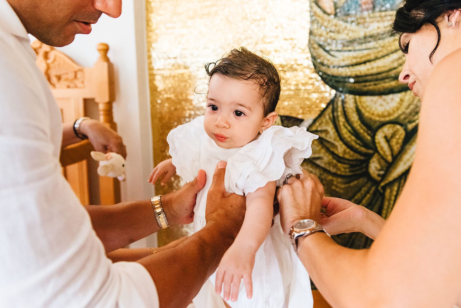 godarents dressing baby Chloe after the christening, St. Andreas Chapel Protaras
