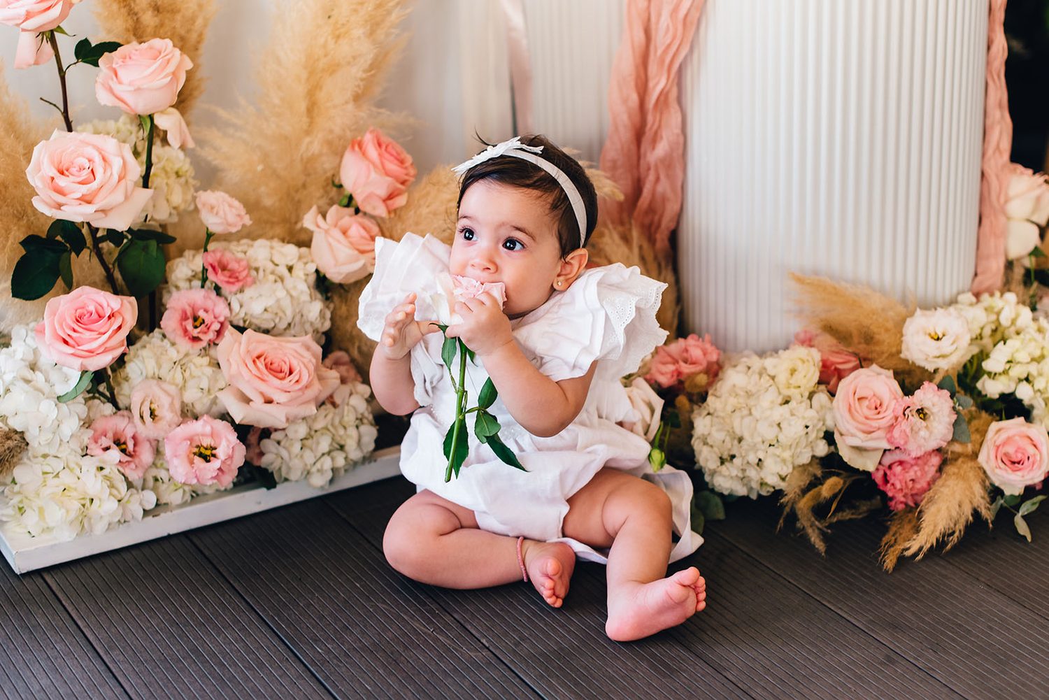 Baby Chloe sitting among pink and white roses at her christening party, Protaras