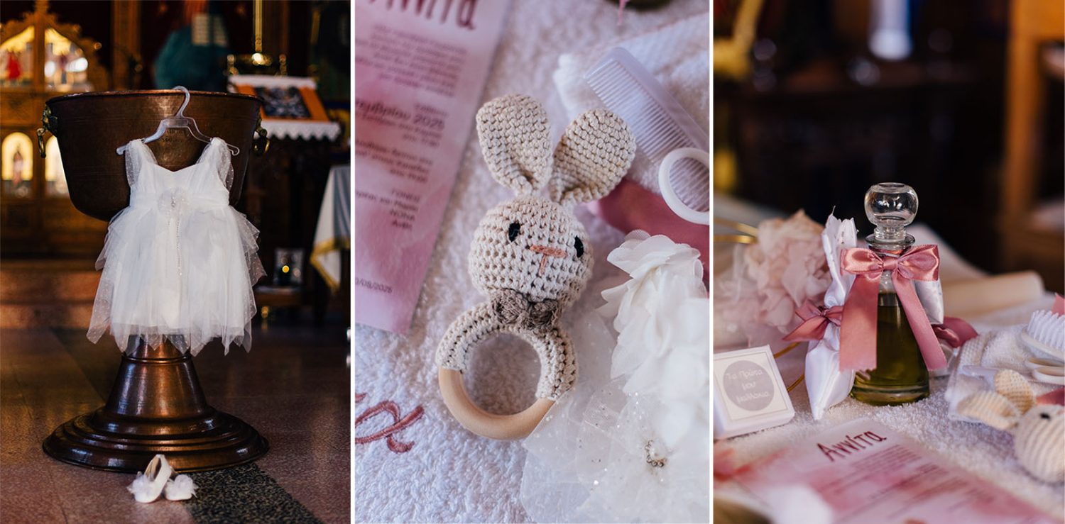 white christening dress hanging by the baptism font, crocheted bunny rattle, and oil bottle with pink ribbon